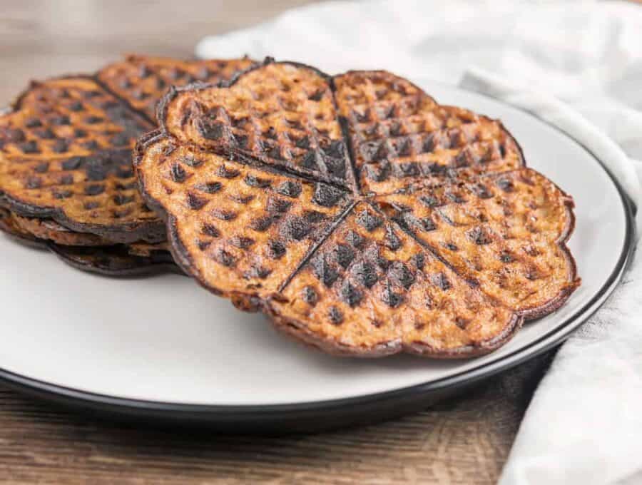 Two chocolate chaffles on a white plate sideways