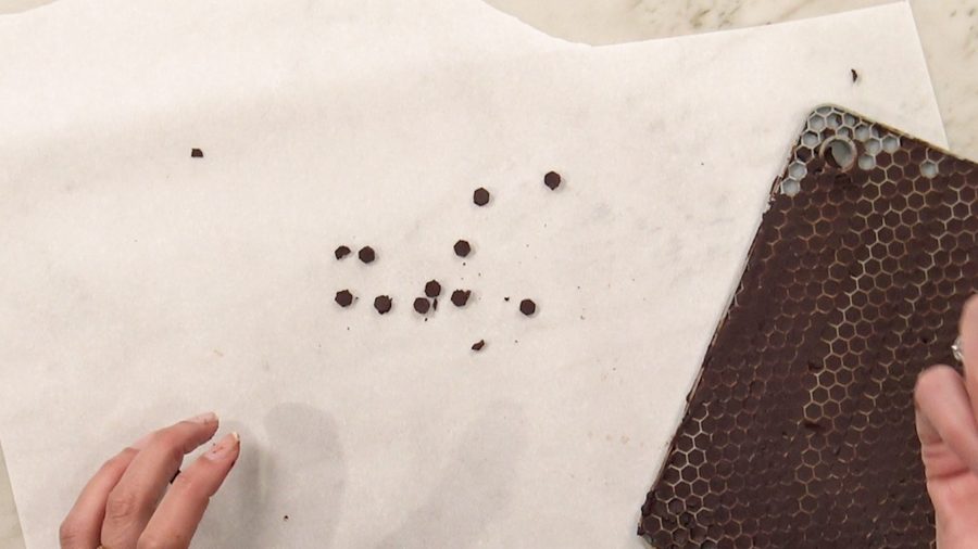 Overhead shot of finished chocolate chips resting on wax paper in order to harden.