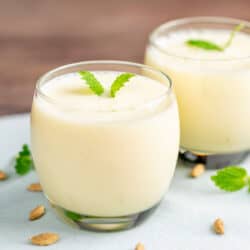 two glasses with mango lassi and garnish