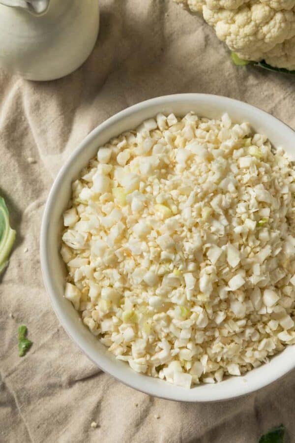 Raw cauliflower rice in a white bowl