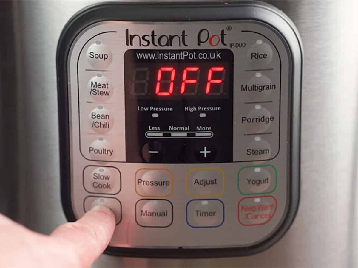 instant pot with OFF in the reading and a finger pushing the button