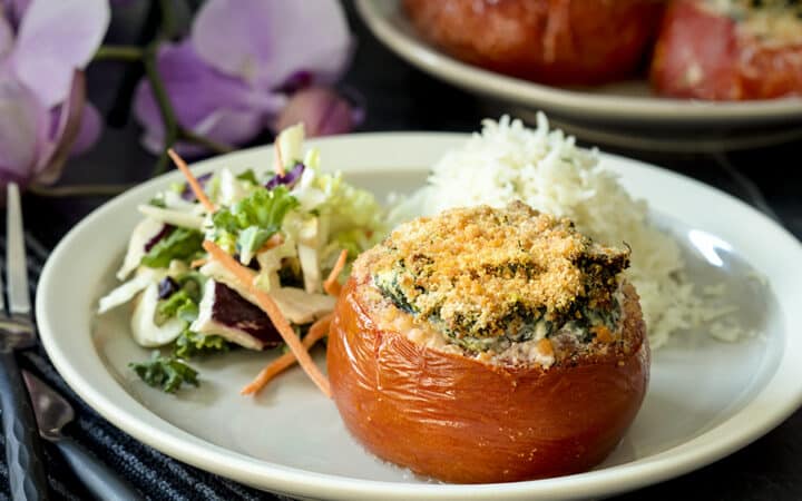 stuffed tomato on a plate with salad