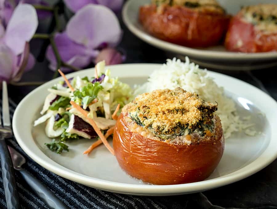 stuffed tomato on a plate with salad