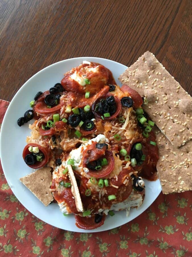 Keto pizza casserole served on a plate with crackers