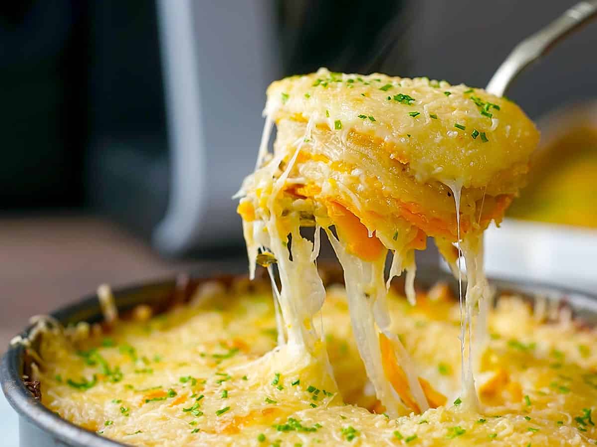 Layered potatoes being lifted out of a pan on a spoon