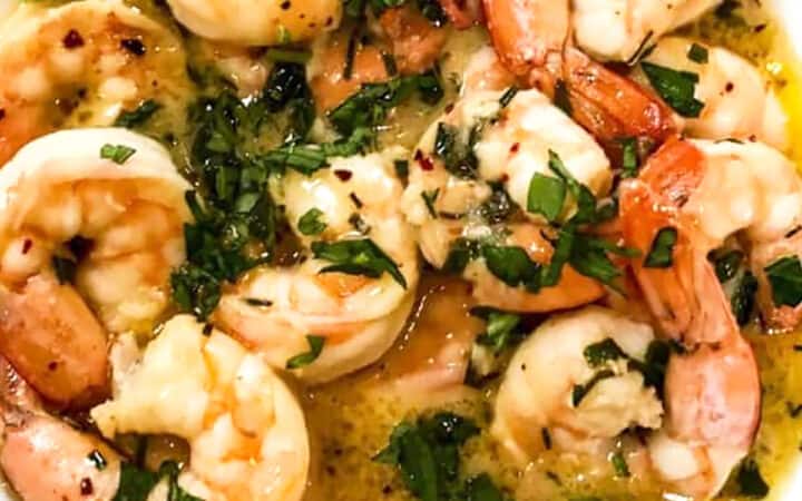 close up of shrimp scampi in a white bowl