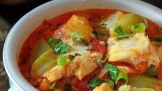 Brazilian Moqueca Fish Stew served in a white bowl with a handle.