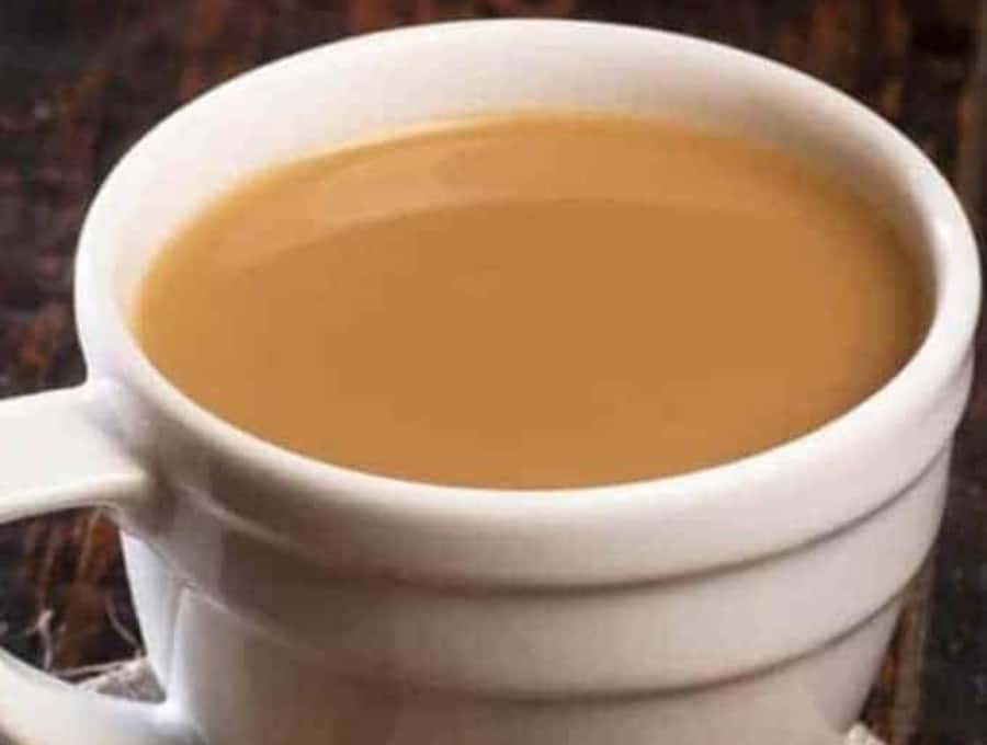 A close up image of masala chai in a white mug.