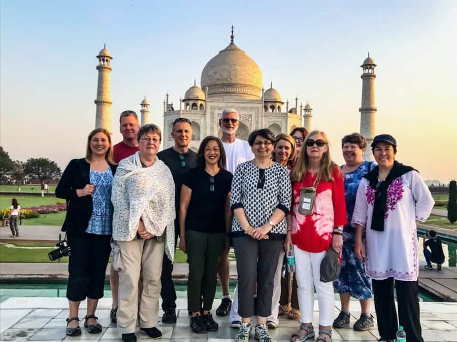 A group of people posing for a photo in front of the Taj Mahal