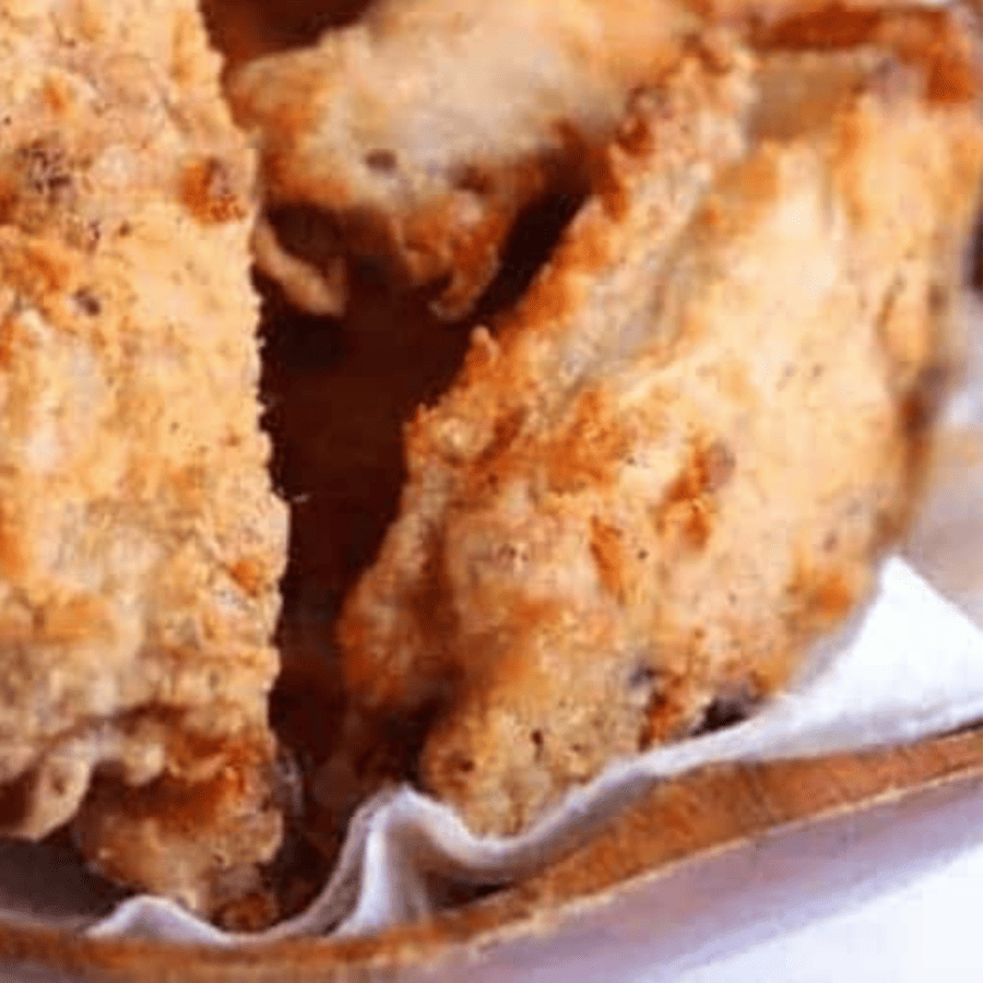 Close up image of air fryer breaded wings in a serving dish