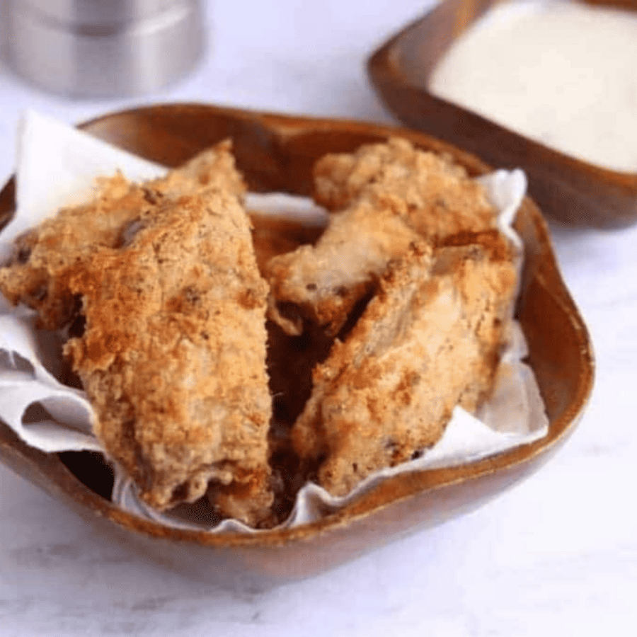 Breaded Chicken Wings on paper towels in a serving bowl