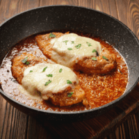 Keto Chicken Parmesan in a large black serving plate