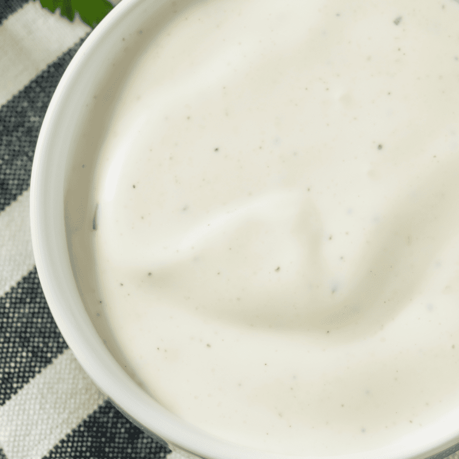 low carb ranch dressing in a white bowl on top of a striped towel