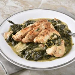 Chicken Florentine sesrved on a white plate with a silver rim