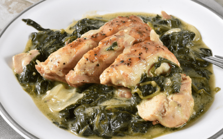 Chicken Florentine sesrved on a white plate with a silver rim