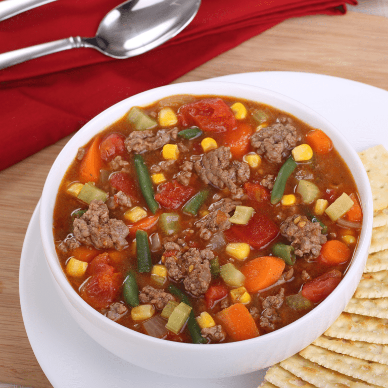 Overhead shot of Instant Pot Vegetable Soup in a white bowl with crackers on the side