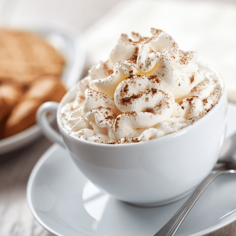 Low Carb Whipped cream in a white mug topped with cinnamon