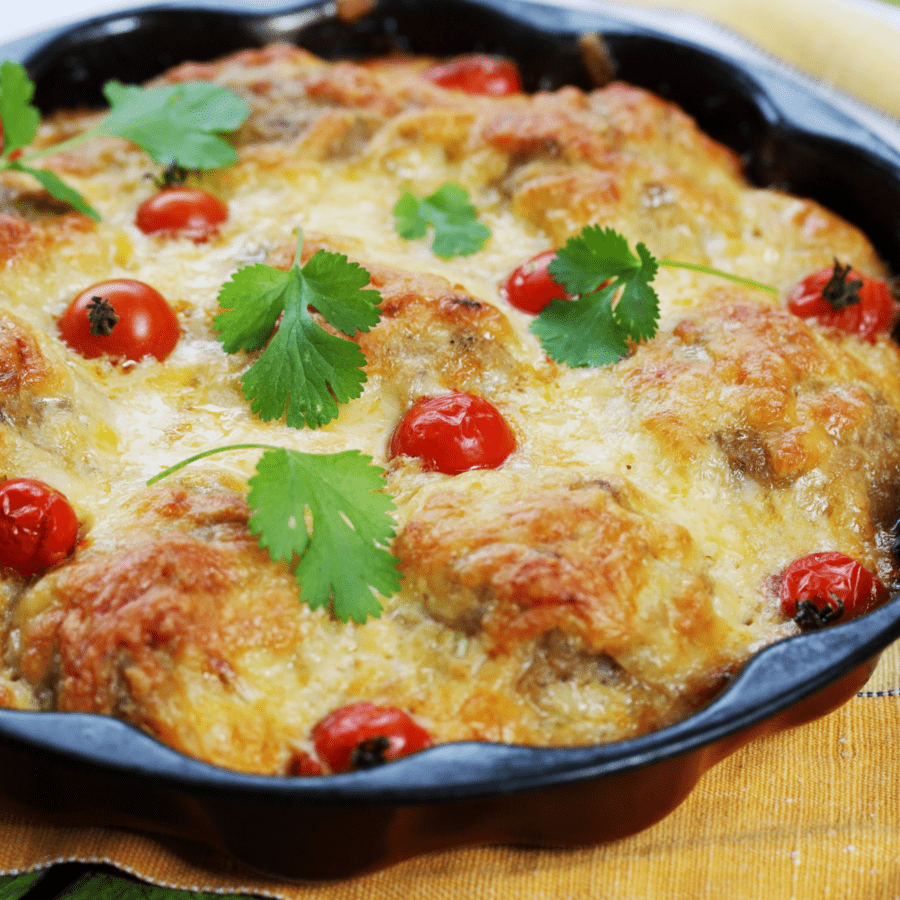 Close up image of meatball casserole in a black skillet