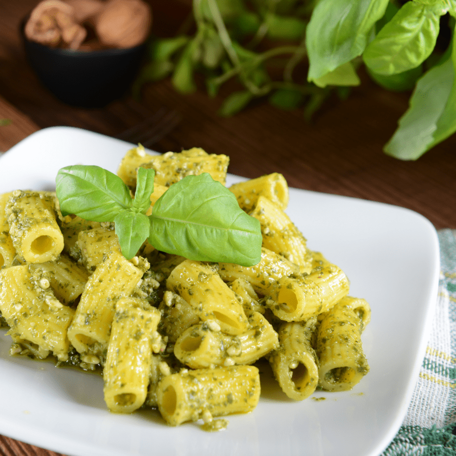 Pesto Pasta served on a white plate with a basil garnish