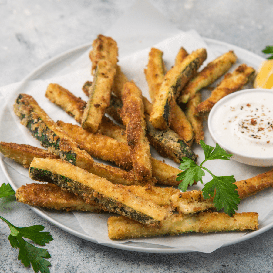 Zucchini Fries on a white plate with dipping sauce