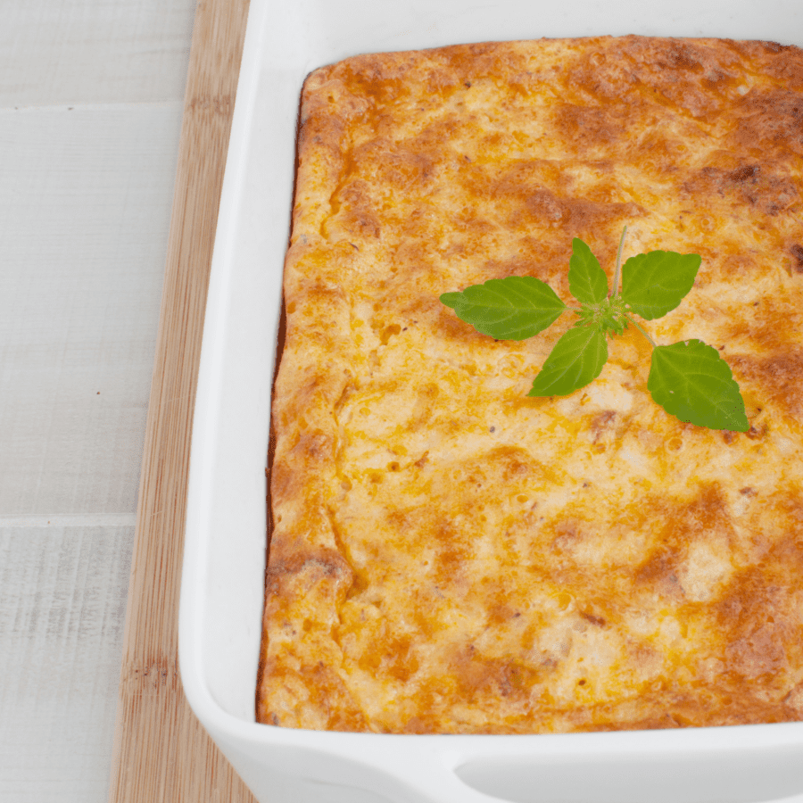Close up image of a keto breakfast casserole with a herb garnish