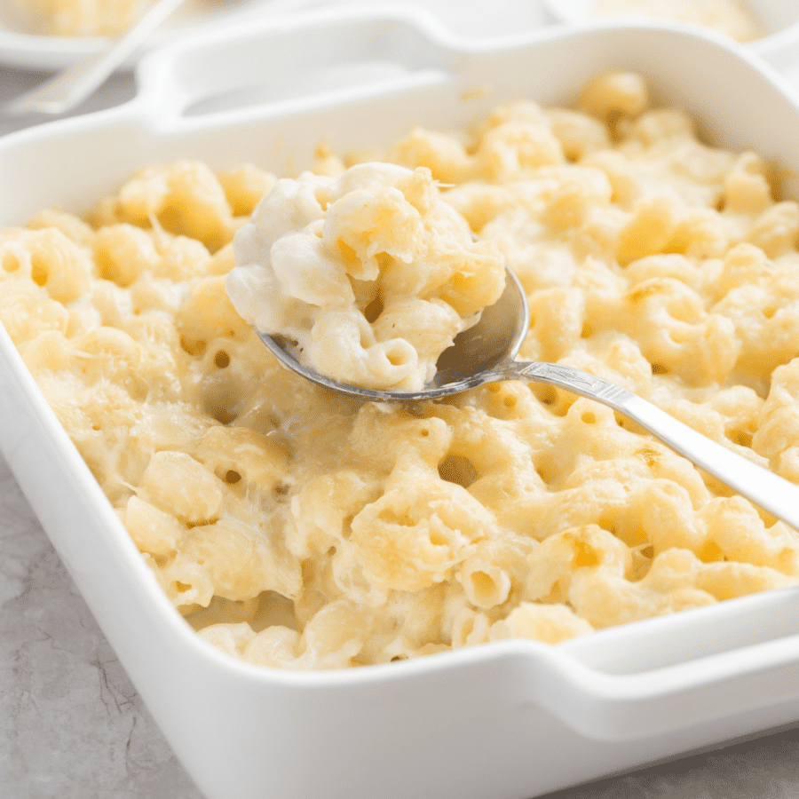panera mac and cheese recipe copycat in a white baking dish with a serving spoon