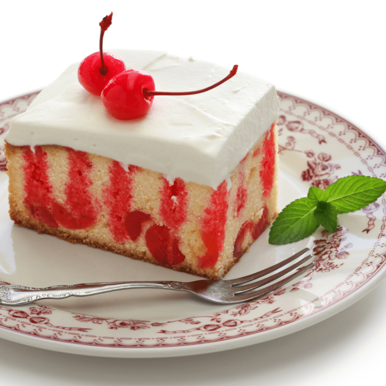 Cherry Poke Cake on a red and white plate with cherry and mint garnish