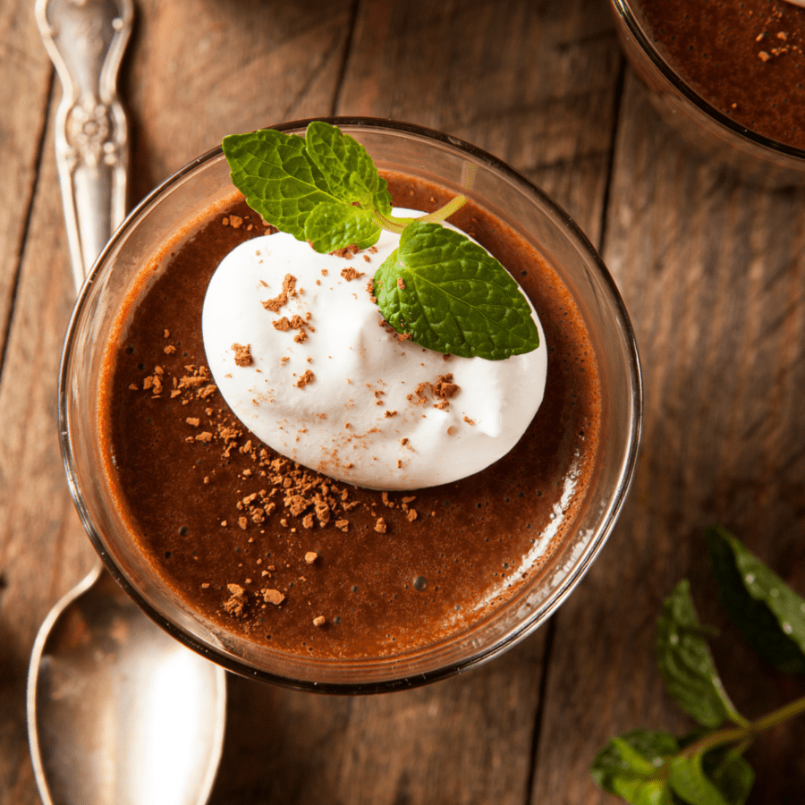 Overhead image of protein pudding with a whipped topping and mint garnish