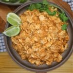 Instant Pot Salsa Chicken on a plate with cilantro and sliced lime