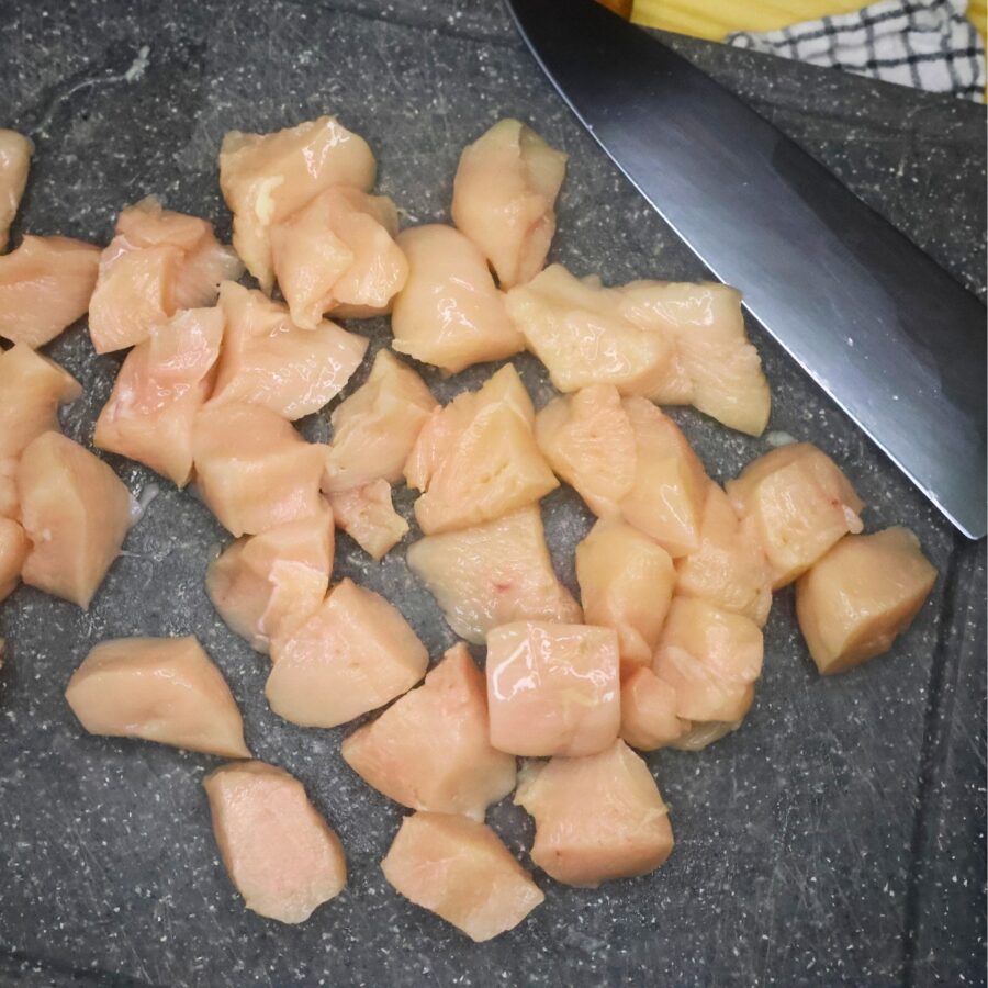 Chicken breasts cut into 1" chunks on a cutting board
