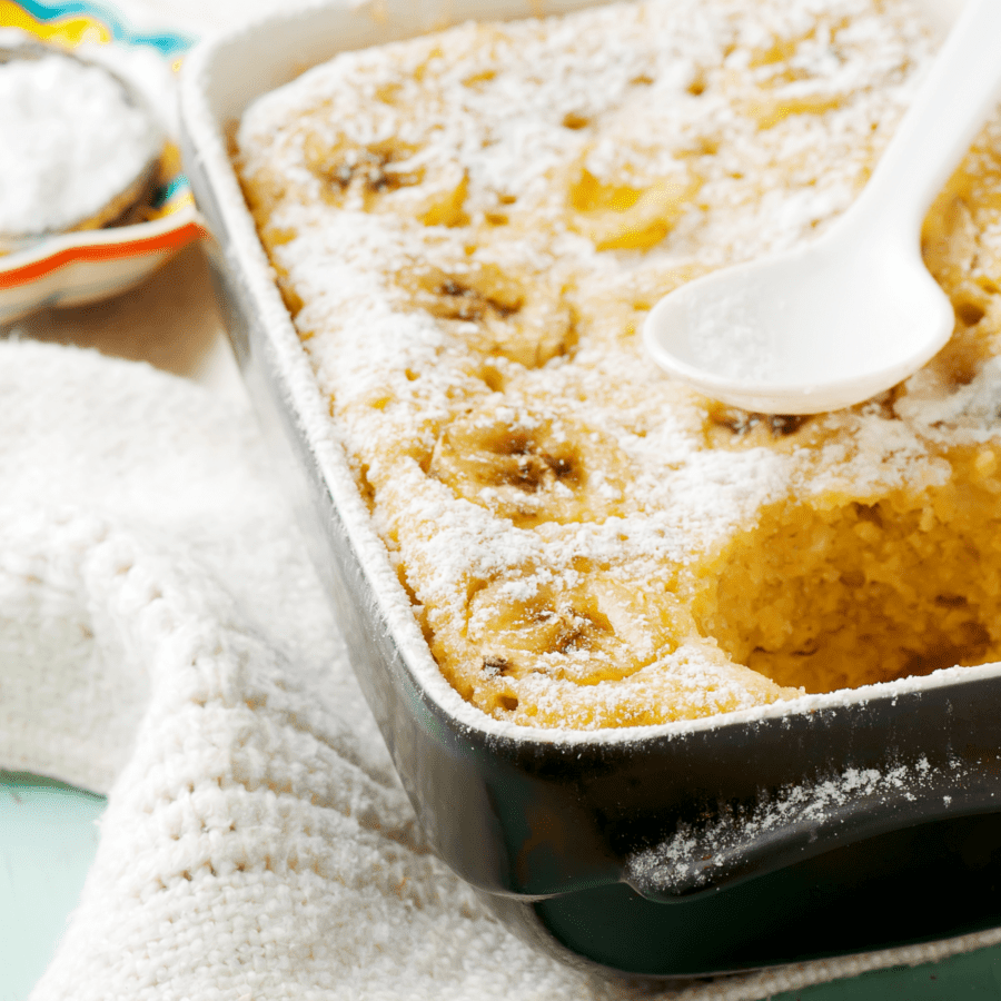 Banana Pudding cake in a baking dish on top of a white towel