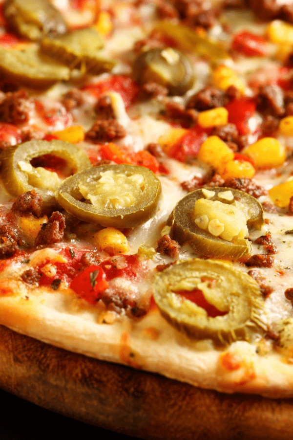 Close up image of a Mexican Pizza on a wooden cutting board