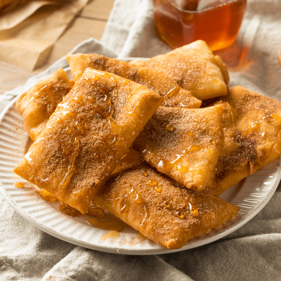 Closeup image of a plate of air fryer sopapillas drizzled with honey