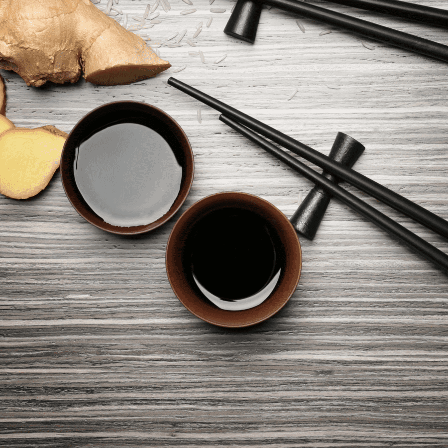 Overhead shot of tofu marinade in two bowls with ginger and chopsticks surrounding them