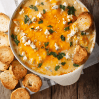 Buffalo Chicken Crock Pot Dip in a round pan served with baguettes