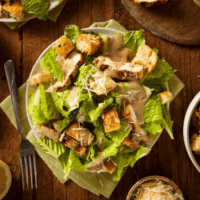 Overhead image of Chicken Caesar Salad on a wooden table