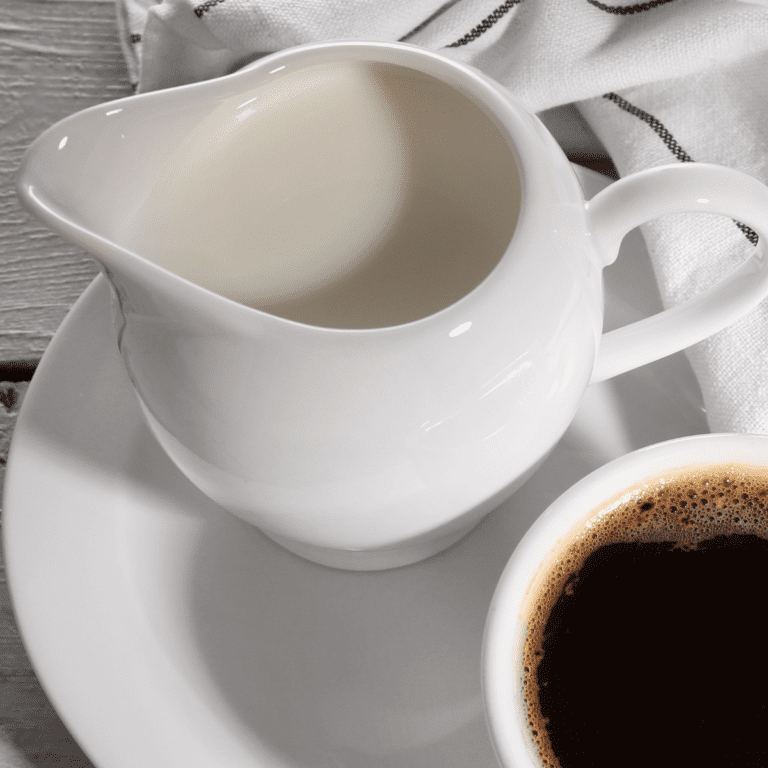 close up image of a jar of keto coffee creamer next to a cup of black coffee