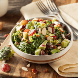 Broccoli Cauliflower Salad in a bowl on a wooden cutting board