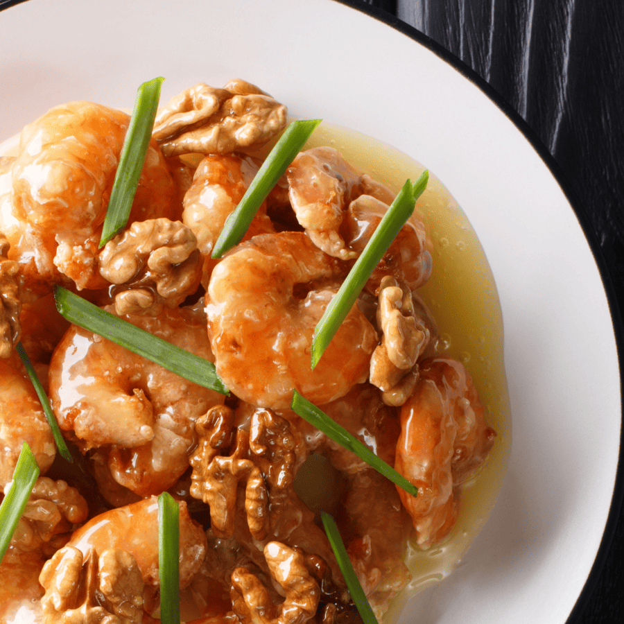 Close up shot of honey walnut shrimp on a white plate