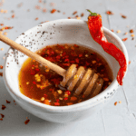 Hot Honey Sauce in a white bowl with a honey drizzler - 8