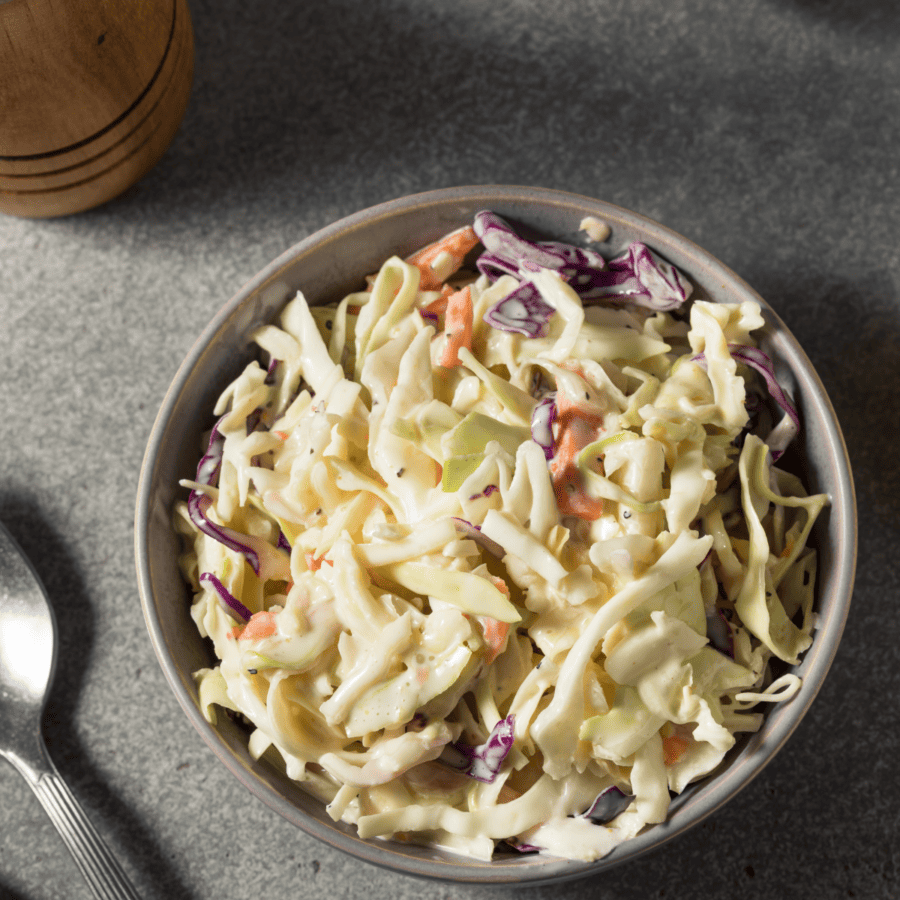 Overhead Image of keto coleslaw in a bowl with a spoon layng next to it