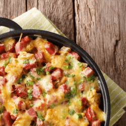 closeup shot of potato casserole with ham in a skillet with handles