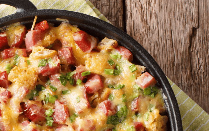 closeup shot of potato casserole with ham in a skillet with handles