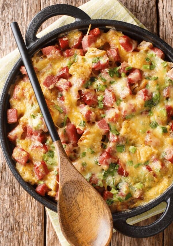 overhead shot of potato casserole in a pan with handles and a wooden spoon over the top