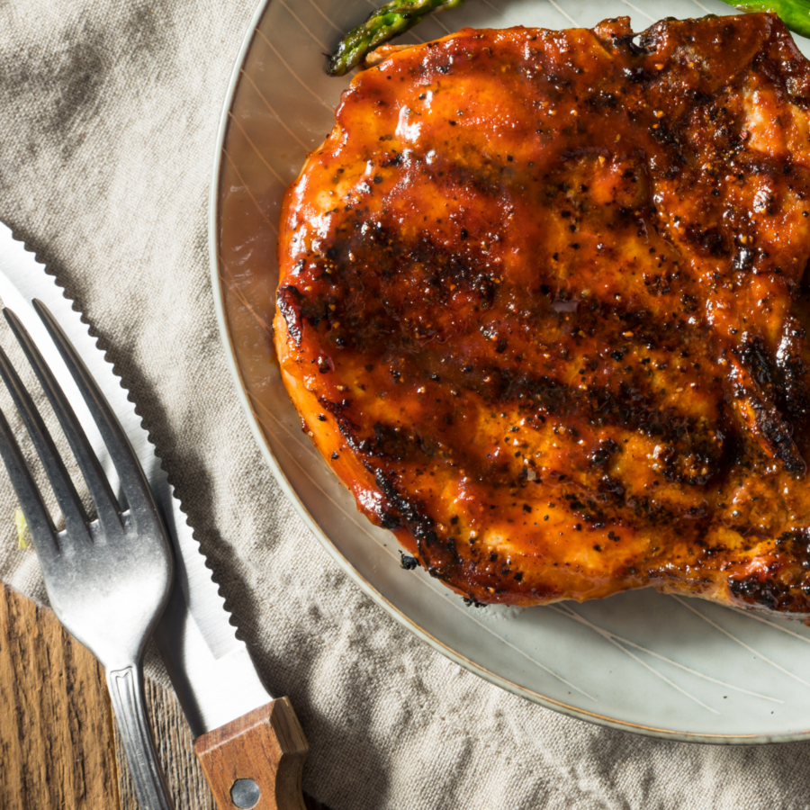 Overhead image of BBQ Pork Chops on a plate with cutlery next to it