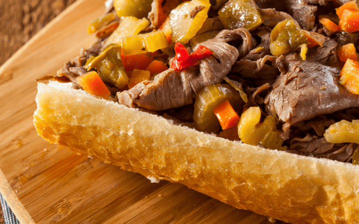 Close up image of an Italian Beef Sandwich on a wooden cutting board
