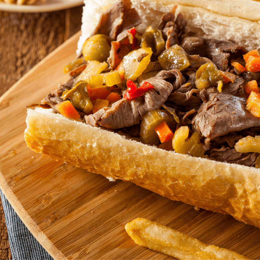 Close up image of an Italian Beef Sandwich on a wooden cutting board
