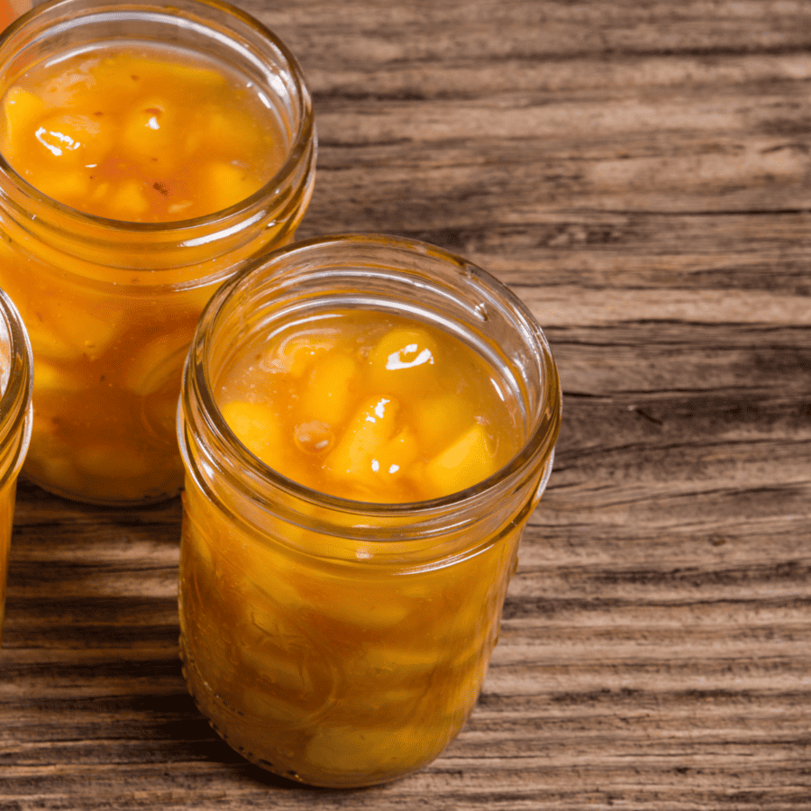 Close up of peach pie filling in glass jars