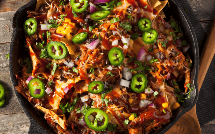 Overhead image of chicken nachos in a cast iron pan
