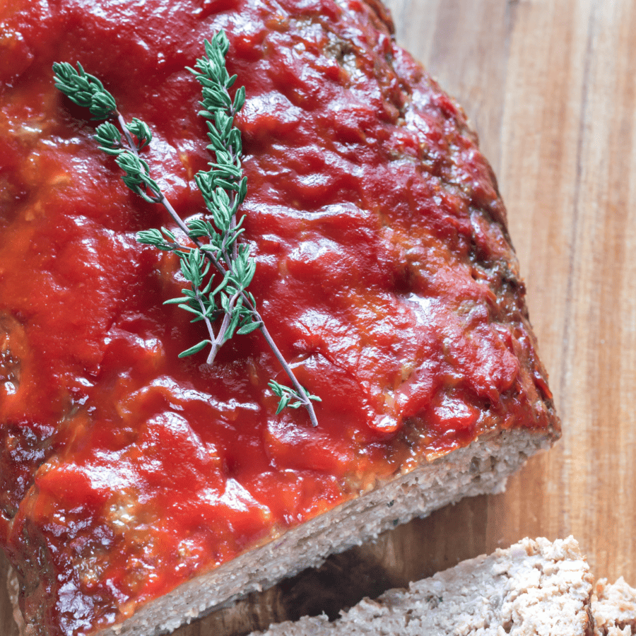 Close up overhead image of italian meatloaf on a cutting board